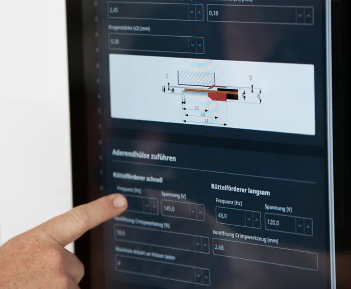 A person points at a touch screen computer, indicating an item or feature on the display.